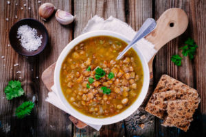 meatless meal with lentil soup in a white bowl, topped with cilantro and with a side of crackers