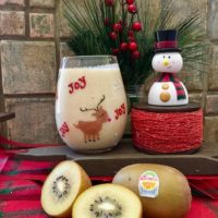 eggnog recipe image with kiwi decorated with a snowman and red holiday decor