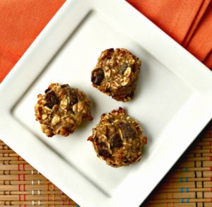 chocolate chip oat protein bites on a white plate with a napkin underneath