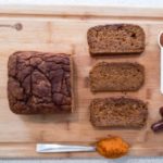 healthy pumpkin bread loaf with slices on a cutting board