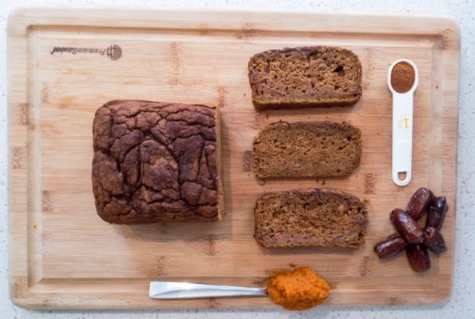 healthy pumpkin bread loaf with slices on a cutting board