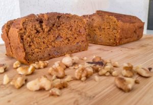 pumpkin bread with walnuts on a wood cutting board