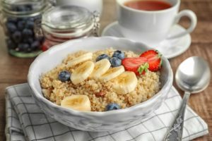 Plate with tasty quinoa on wooden table