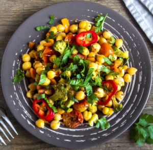 Homemade spicy vegetarian stew with chickpeas and vegetables on plate close up - healthy vegetarian food