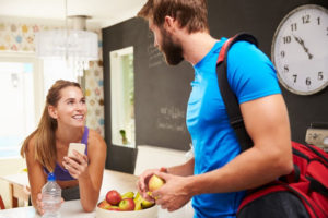 man and woman in kitchen with fruit bowl deciding what to eat before working out - melissashealthyliving.com