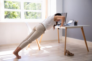 Businesswoman Doing Push Up On Office Desk exercise at work